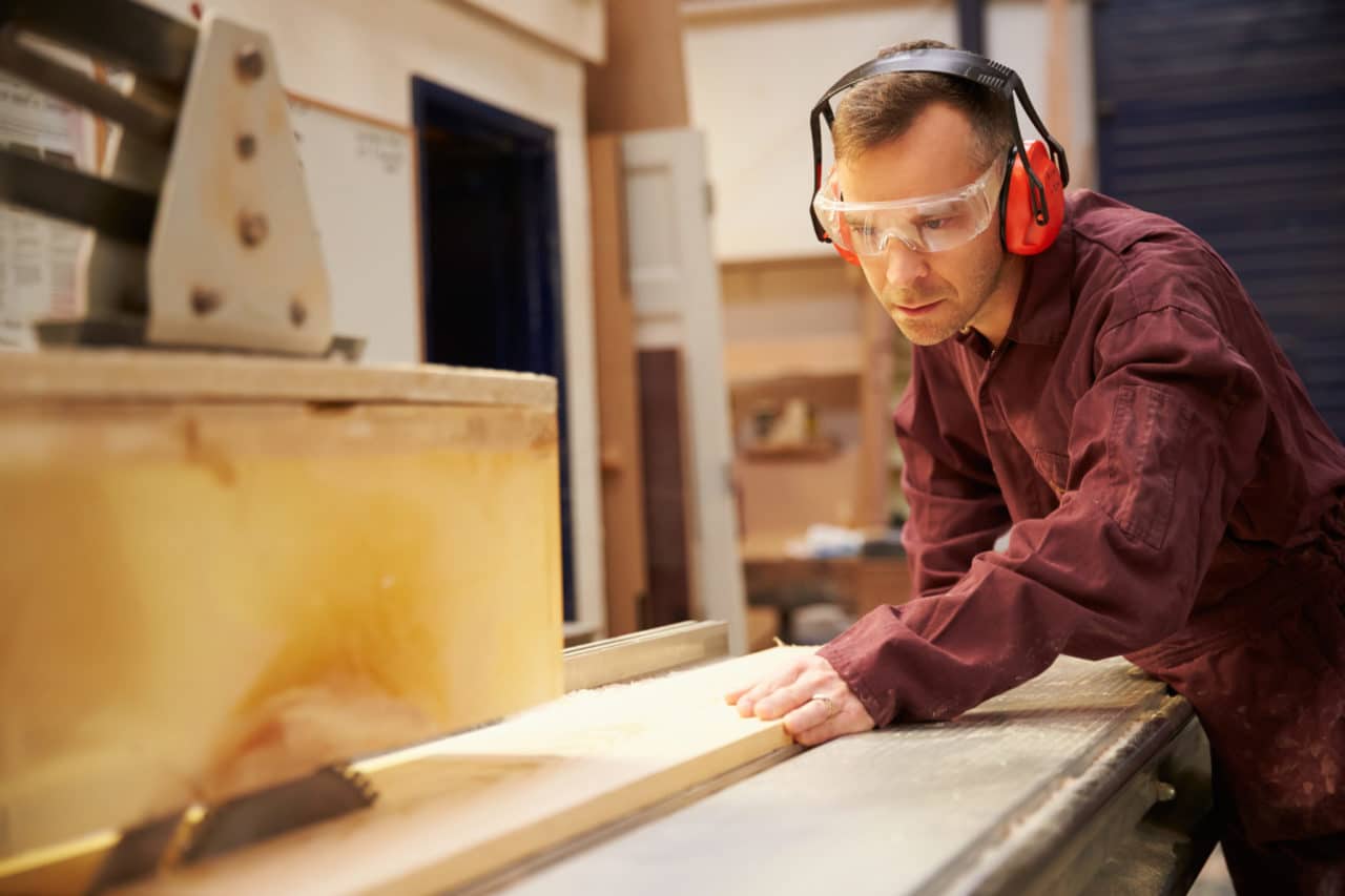 Person woodworking with power tools and hearing protection
