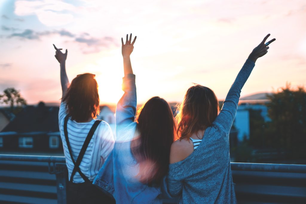 three girls celebrating the benefits of hearing aids