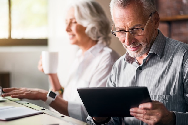 Elderly couple together wearing glasses at the kitchen