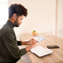 Man connecting hearing aid to his tablet.