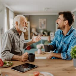 Young man talking to his father over coffee