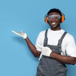 Young man wearing gloves, goggles and hearing protective equipment