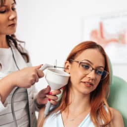 ENT removing a woman's earwax with irrigation.